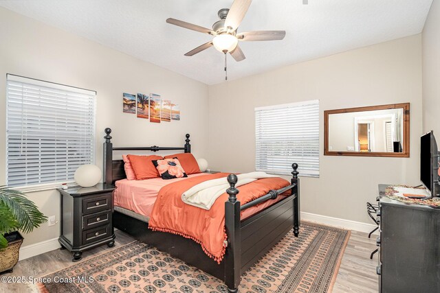 7703 Windover Way, Titusville, FL 32780 - bedroom with light wood-type flooring, a ceiling fan, and baseboards