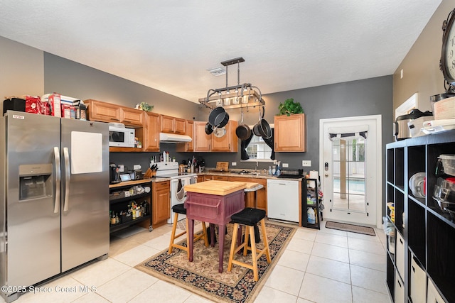 7703 Windover Way, Titusville, FL 32780 - kitchen with light countertops, light tile patterned floors, under cabinet range hood, and white appliances