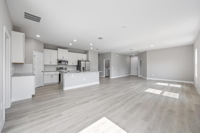 unfurnished living room with baseboards, recessed lighting, light wood-style flooring, and visible vents