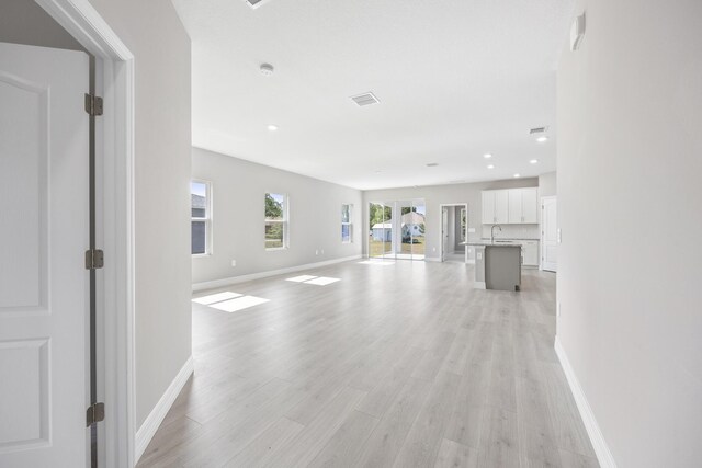 unfurnished living room with recessed lighting, baseboards, visible vents, and light wood-style floors