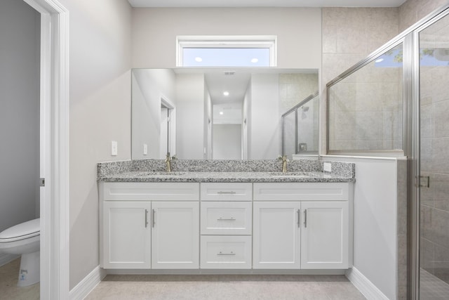 bathroom with a sink, a shower stall, toilet, and double vanity