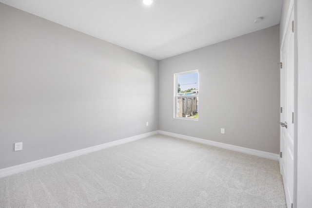 empty room with baseboards and light carpet