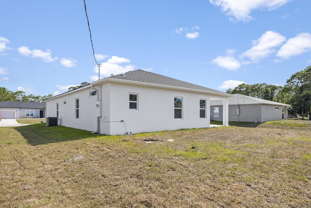 back of property with stucco siding, a yard, and cooling unit