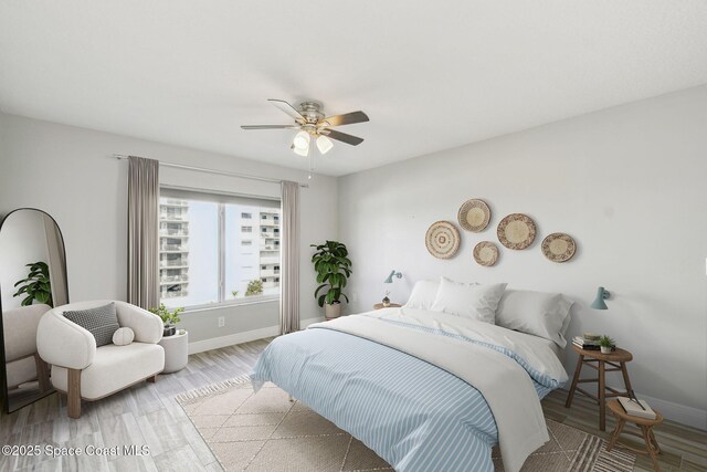 bedroom with baseboards, ceiling fan, and wood finished floors