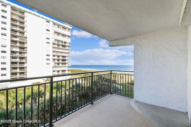 balcony with a water view and a view of the beach