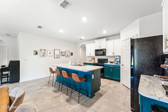 5985 Orsino Ln, Cocoa, FL 32926 - kitchen with black appliances, arched walkways, a sink, a kitchen bar, and light countertops