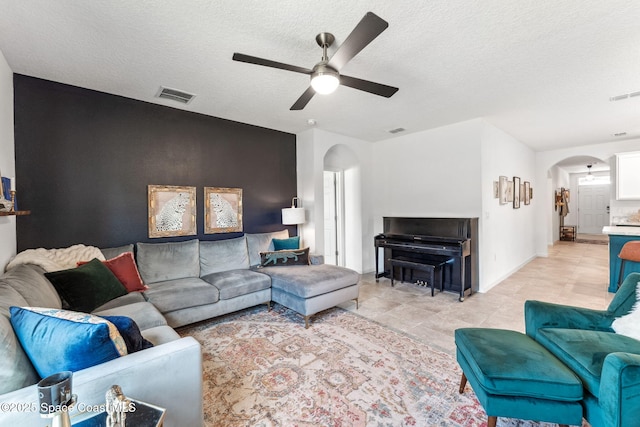 5985 Orsino Ln, Cocoa, FL 32926 - living room featuring arched walkways, a ceiling fan, a textured ceiling, baseboards, and light tile patterned floors