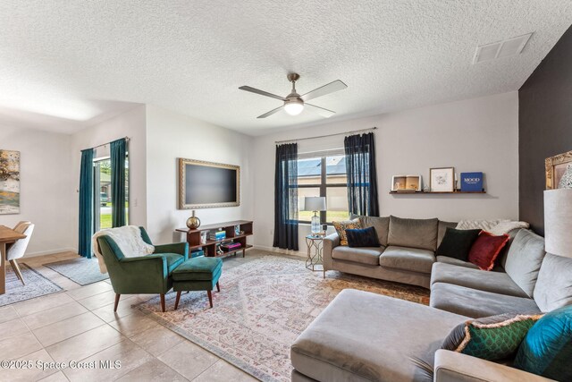 5985 Orsino Ln, Cocoa, FL 32926 - living room with a ceiling fan, a textured ceiling, baseboards, and light tile patterned flooring