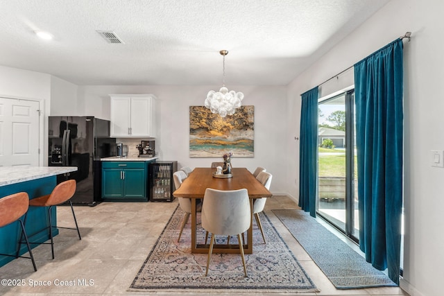 5985 Orsino Ln, Cocoa, FL 32926 - dining space featuring beverage cooler, a chandelier, and a textured ceiling