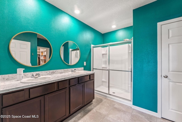 5985 Orsino Ln, Cocoa, FL 32926 - bathroom featuring a textured ceiling, a stall shower, double vanity, tile patterned flooring, and a textured wall