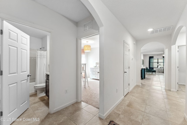 5985 Orsino Ln, Cocoa, FL 32926 - hallway with arched walkways, baseboards, and light tile patterned flooring