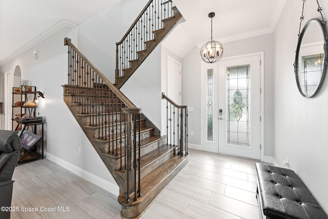 7773 Desmond Ave, Melbourne, FL 32940 - entrance foyer featuring arched walkways, stairway, crown molding, a chandelier, and baseboards
