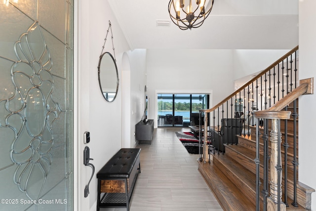 7773 Desmond Ave, Melbourne, FL 32940 - entryway featuring stairway, a chandelier, and a high ceiling
