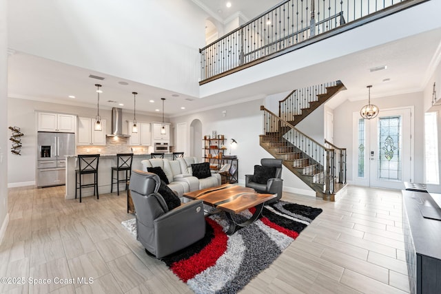 7773 Desmond Ave, Melbourne, FL 32940 - living area with arched walkways, stairway, a high ceiling, ornamental molding, and recessed lighting