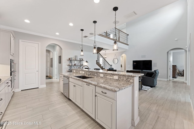 7773 Desmond Ave, Melbourne, FL 32940 - kitchen with arched walkways, a sink, appliances with stainless steel finishes, open floor plan, and baseboards