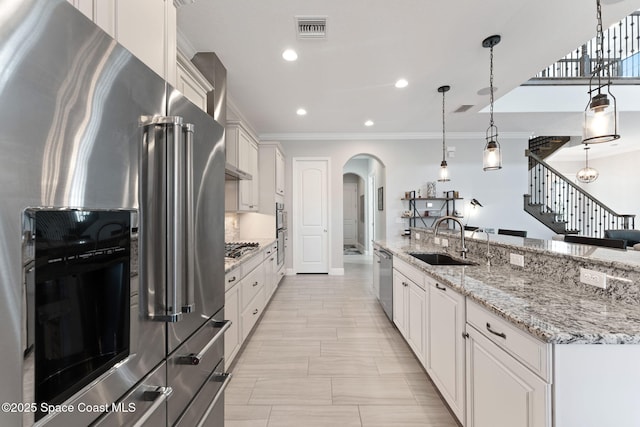 7773 Desmond Ave, Melbourne, FL 32940 - kitchen with stainless steel appliances, a sink, arched walkways, ornamental molding, and recessed lighting