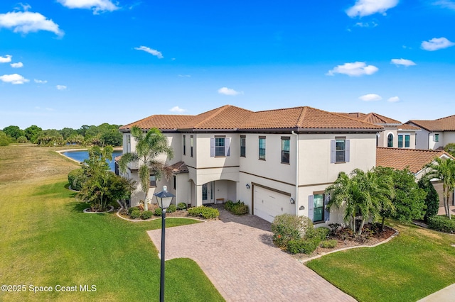 7773 Desmond Ave, Melbourne, FL 32940 - mediterranean / spanish-style home with decorative driveway, a tile roof, a garage, a water view, and a front yard
