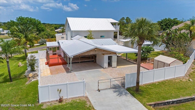8865 Central Ave, Micco, FL 32976 - view of front facade featuring a gate, concrete driveway, a carport, and metal roof