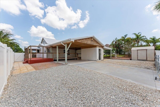8865 Central Ave, Micco, FL 32976 - view of front of house featuring a storage unit, fence, an outdoor structure, concrete driveway, and metal roof