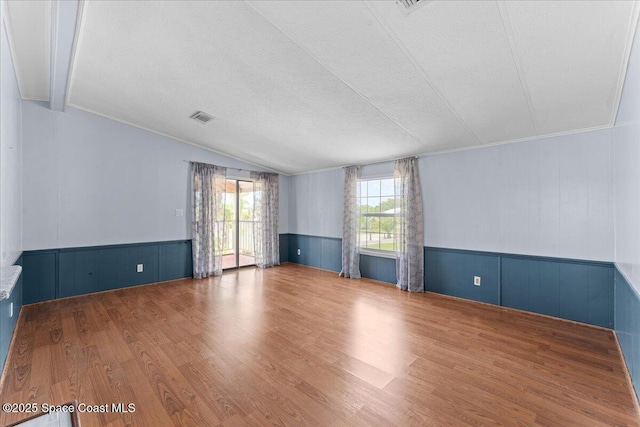 8865 Central Ave, Micco, FL 32976 - unfurnished room featuring wood finished floors, vaulted ceiling, and wainscoting