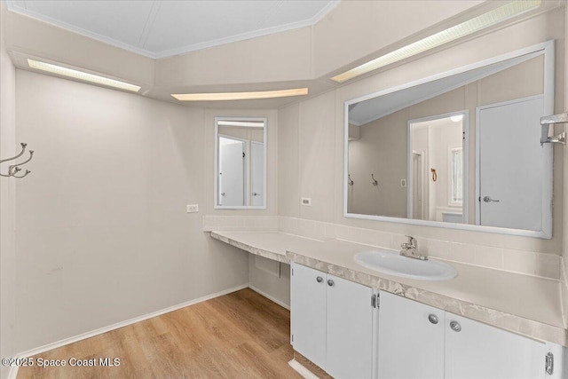 8865 Central Ave, Micco, FL 32976 - bathroom with crown molding, wood finished floors, vanity, and baseboards