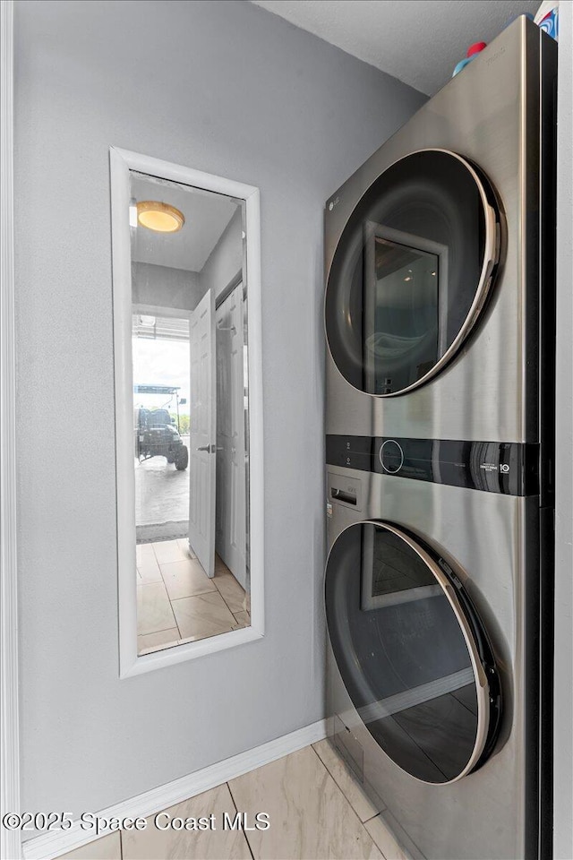 8865 Central Ave, Micco, FL 32976 - laundry room with stacked washer / dryer, baseboards, and marble finish flooring