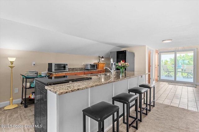 8865 Central Ave, Micco, FL 32976 - kitchen featuring smart refrigerator, a sink, a kitchen island with sink, lofted ceiling, and a breakfast bar area
