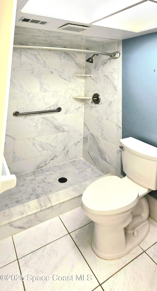bathroom with toilet, a shower stall, and marble finish floors