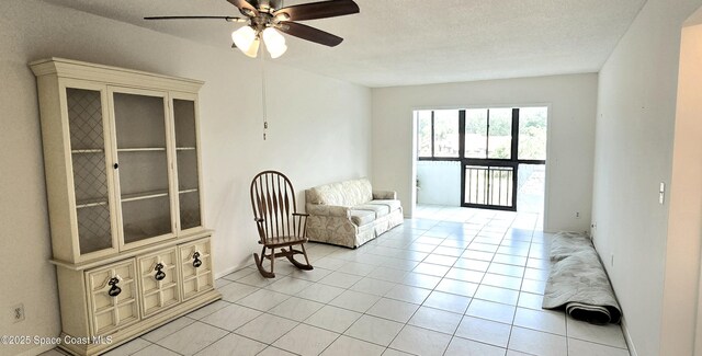 sitting room with ceiling fan and light tile patterned flooring
