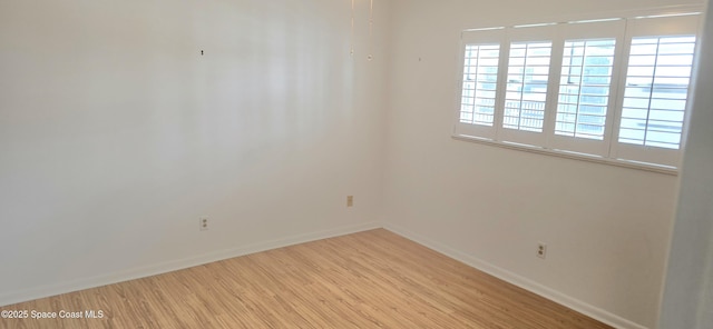 spare room with wood finished floors and baseboards