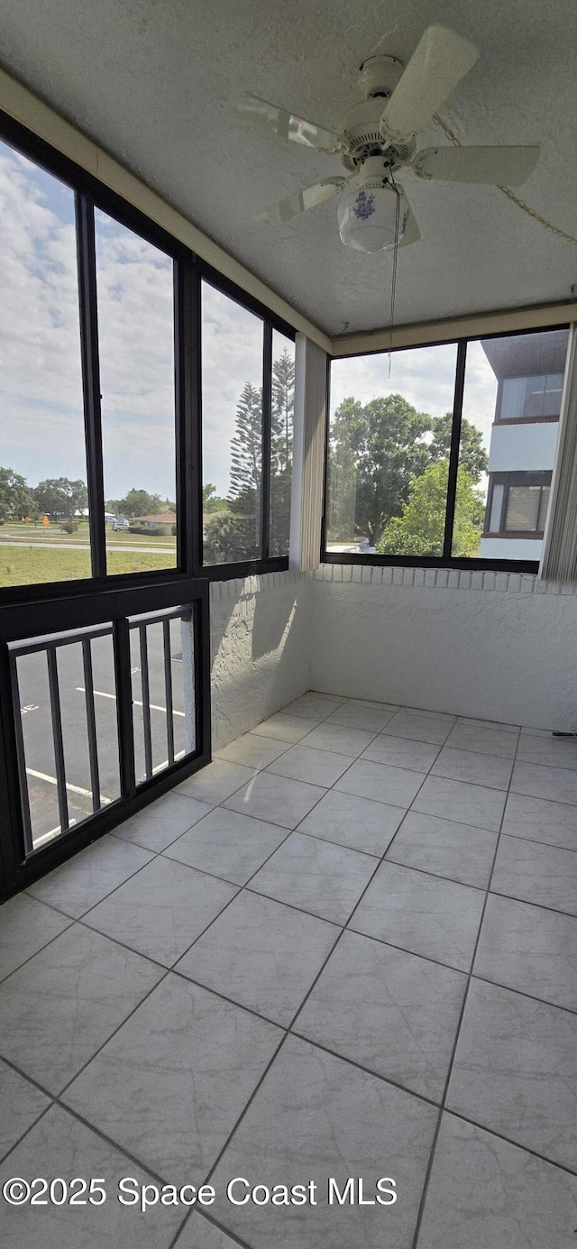 unfurnished sunroom featuring a ceiling fan