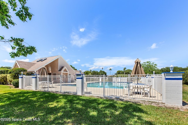 community pool featuring a yard, a patio, and fence