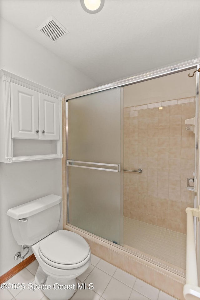 bathroom featuring a shower stall, toilet, tile patterned flooring, and visible vents