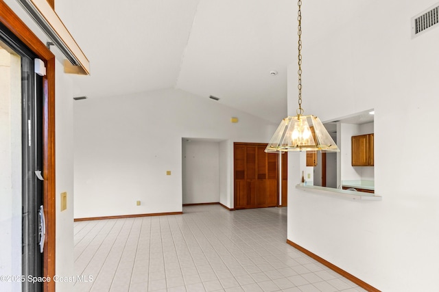 empty room featuring visible vents, baseboards, and high vaulted ceiling