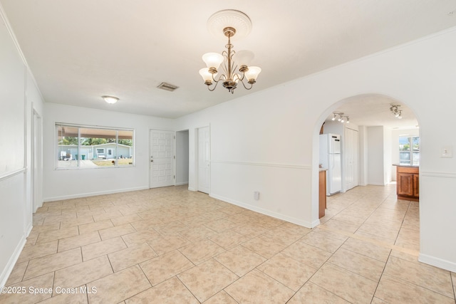 unfurnished room featuring light tile patterned flooring, a notable chandelier, arched walkways, visible vents, and ornamental molding