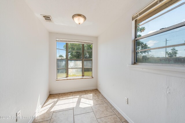 unfurnished room with light tile patterned floors, baseboards, and visible vents