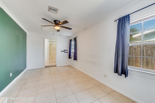 unfurnished room featuring light tile patterned flooring, a textured ceiling, a ceiling fan, visible vents, and ornamental molding