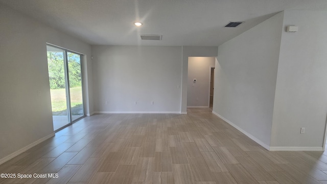 unfurnished room featuring baseboards and light wood finished floors