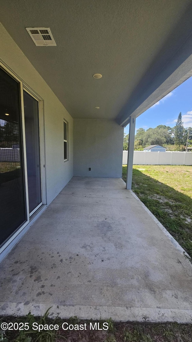 view of patio with fence and visible vents