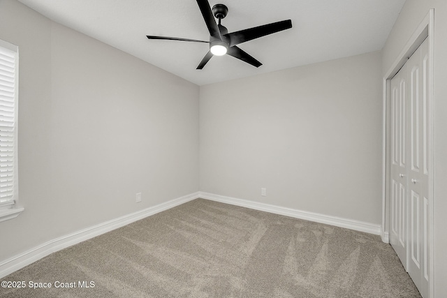 unfurnished bedroom featuring baseboards, carpet, and a closet