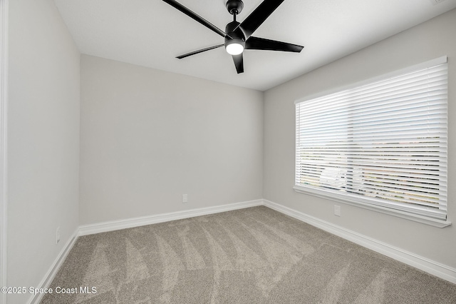 carpeted empty room featuring a ceiling fan and baseboards