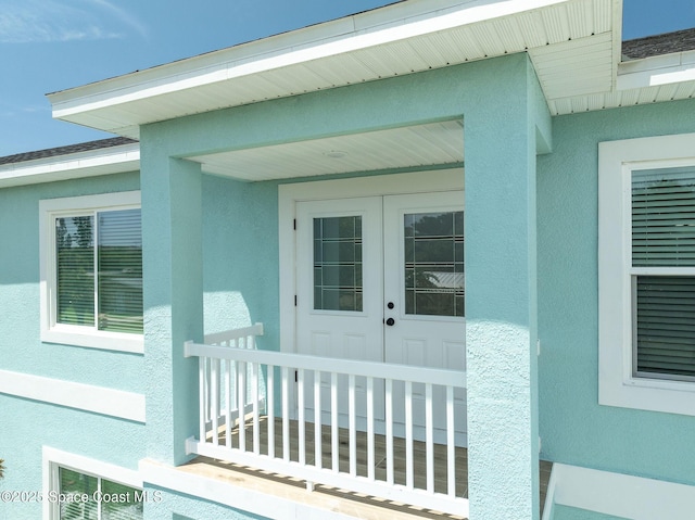 view of exterior entry with french doors and stucco siding
