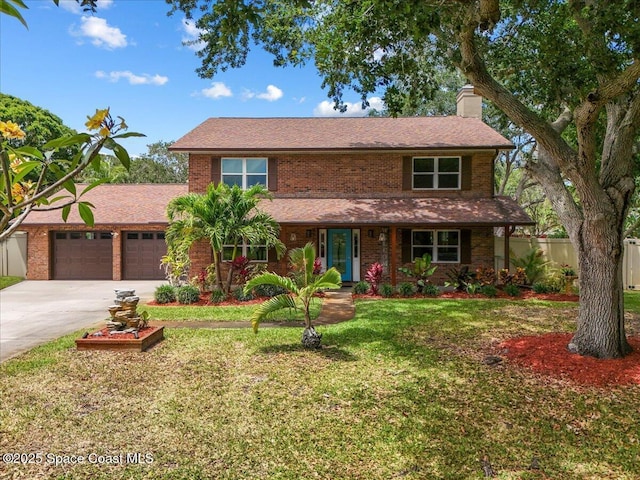 traditional-style home with fence, an attached garage, a front yard, a chimney, and driveway