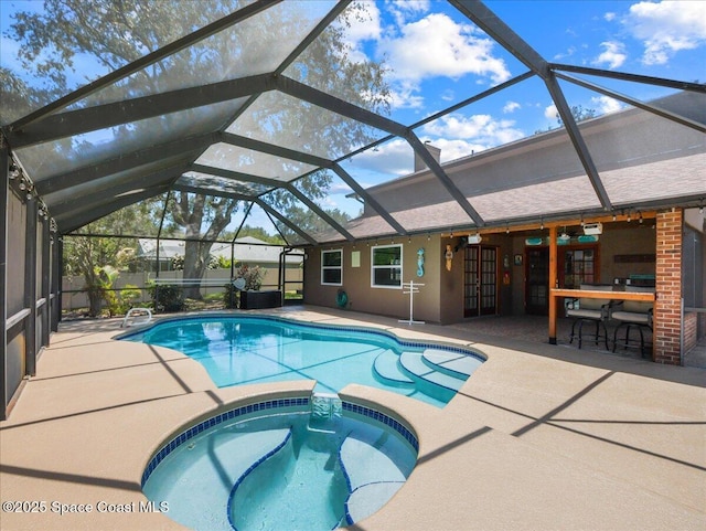 view of pool featuring a patio, a lanai, and a pool with connected hot tub