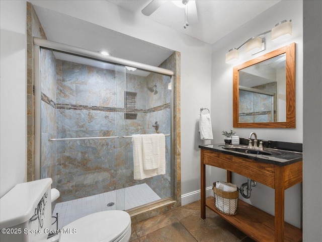 full bathroom with a ceiling fan, toilet, baseboards, a sink, and a stall shower