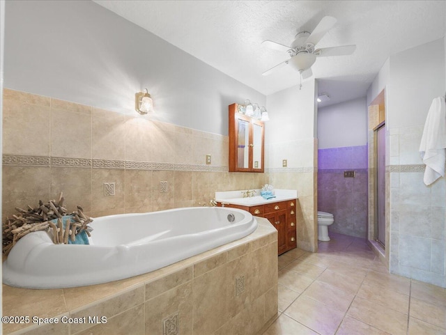 full bath featuring vanity, tile patterned flooring, toilet, tile walls, and a shower stall