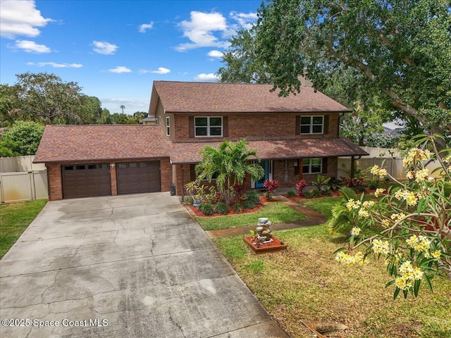 view of front of house with brick siding, fence, a front lawn, and a garage