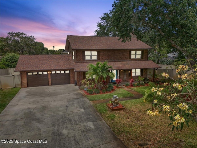 view of front of house with fence, an attached garage, concrete driveway, and brick siding