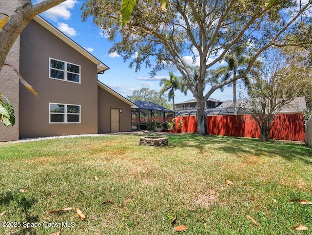 view of yard featuring glass enclosure and a fenced backyard