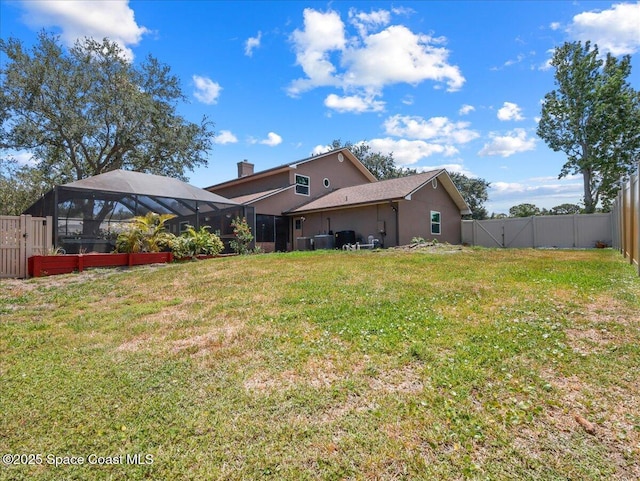 rear view of house featuring a fenced backyard, a chimney, a lawn, and stucco siding